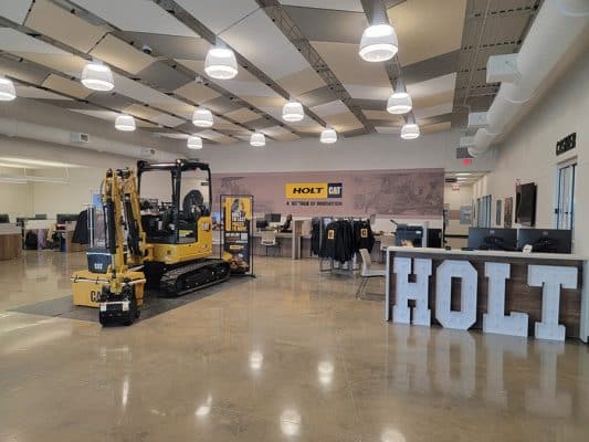 a Caterpillar 302.7 CR mini excavator displayed inside a Holt CAT dealership